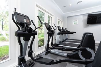 a room with a row of exercise machines in front of a window at Missions at Chino Hills, California, 91709